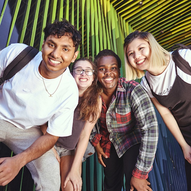 students smiling under colourful walkway